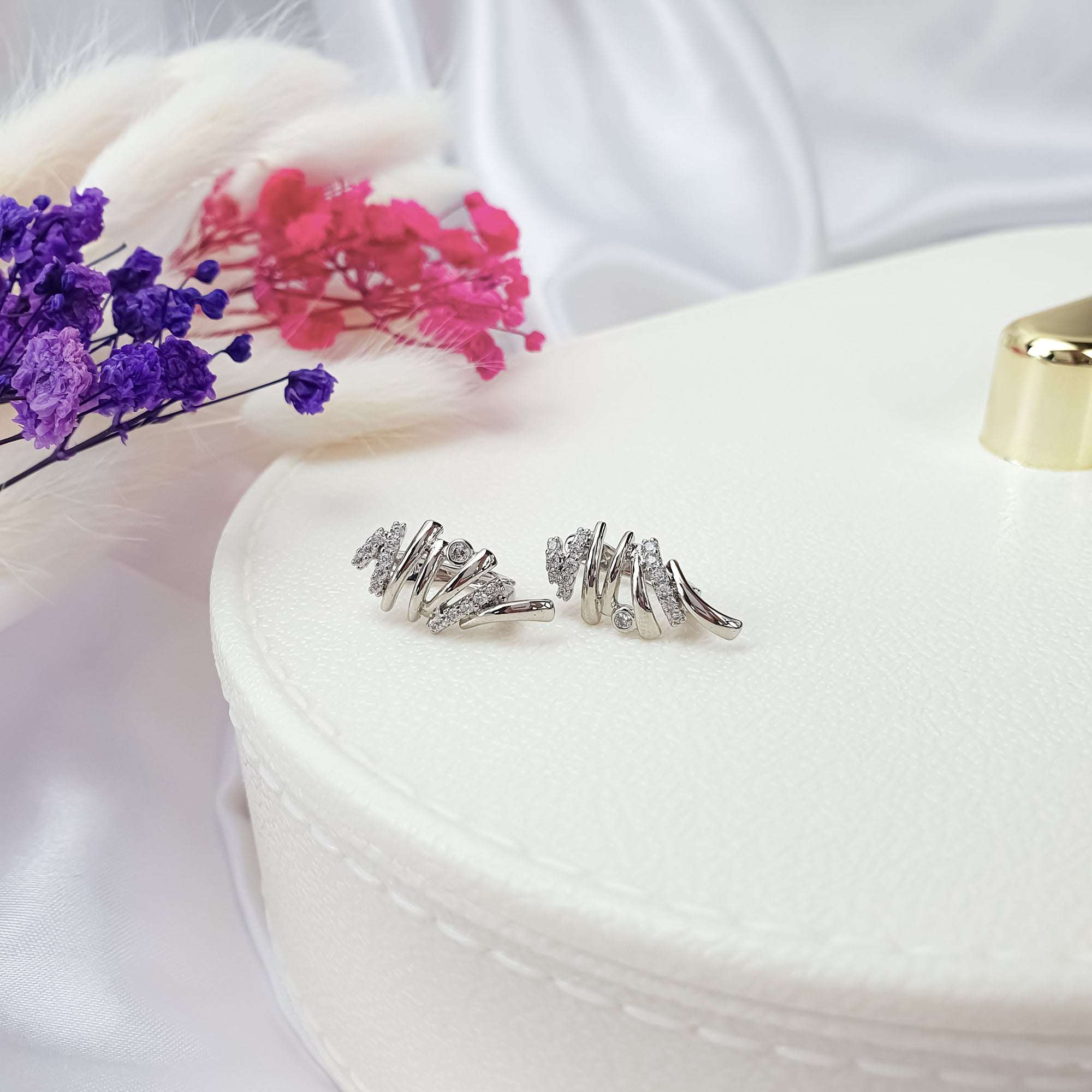 Eleganti auskari ar vijīgu līniju formu un akmeņu mirdzumu