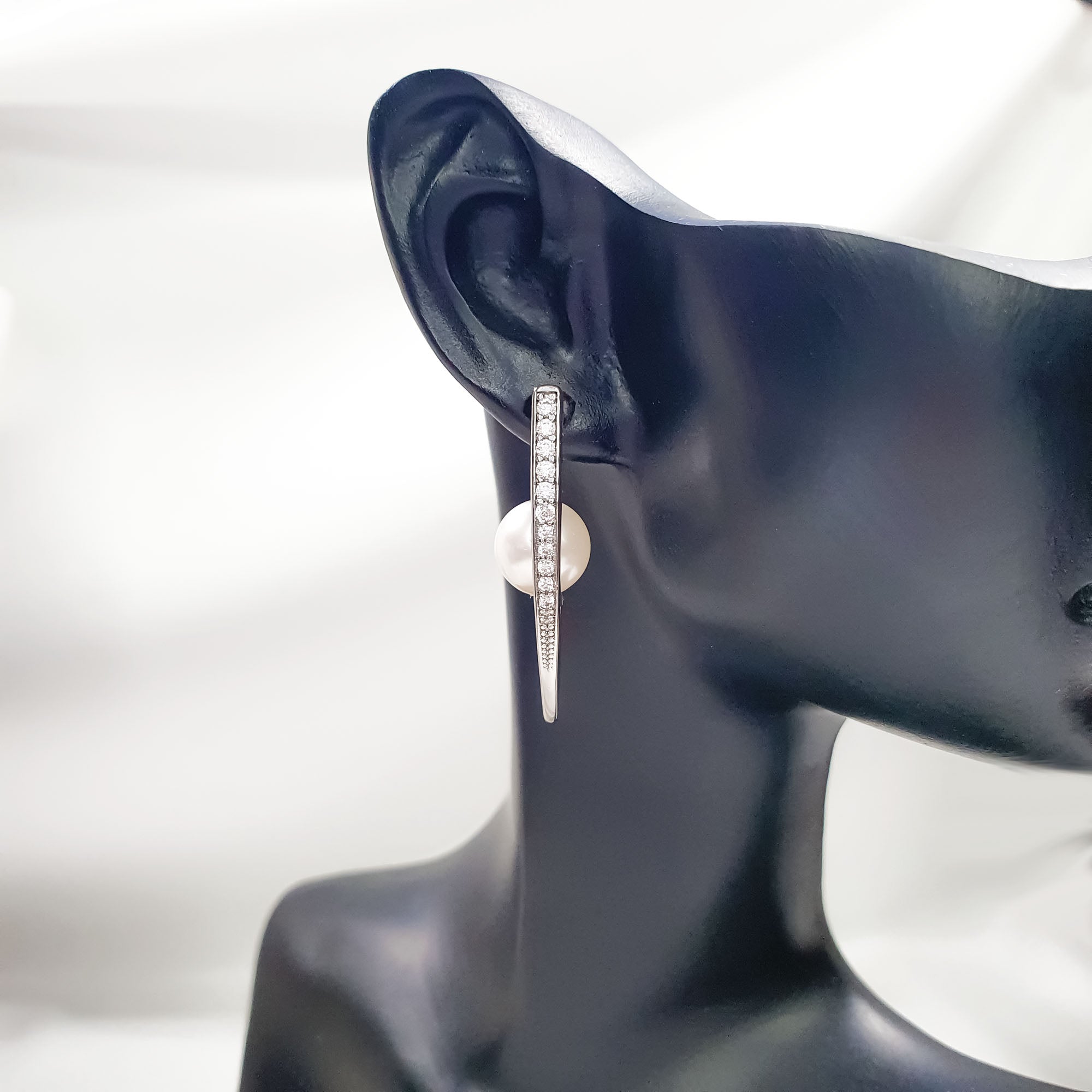 Auskari ar V-veida rāmi balto akmentiņu klājumu un angļu tipa aizdari