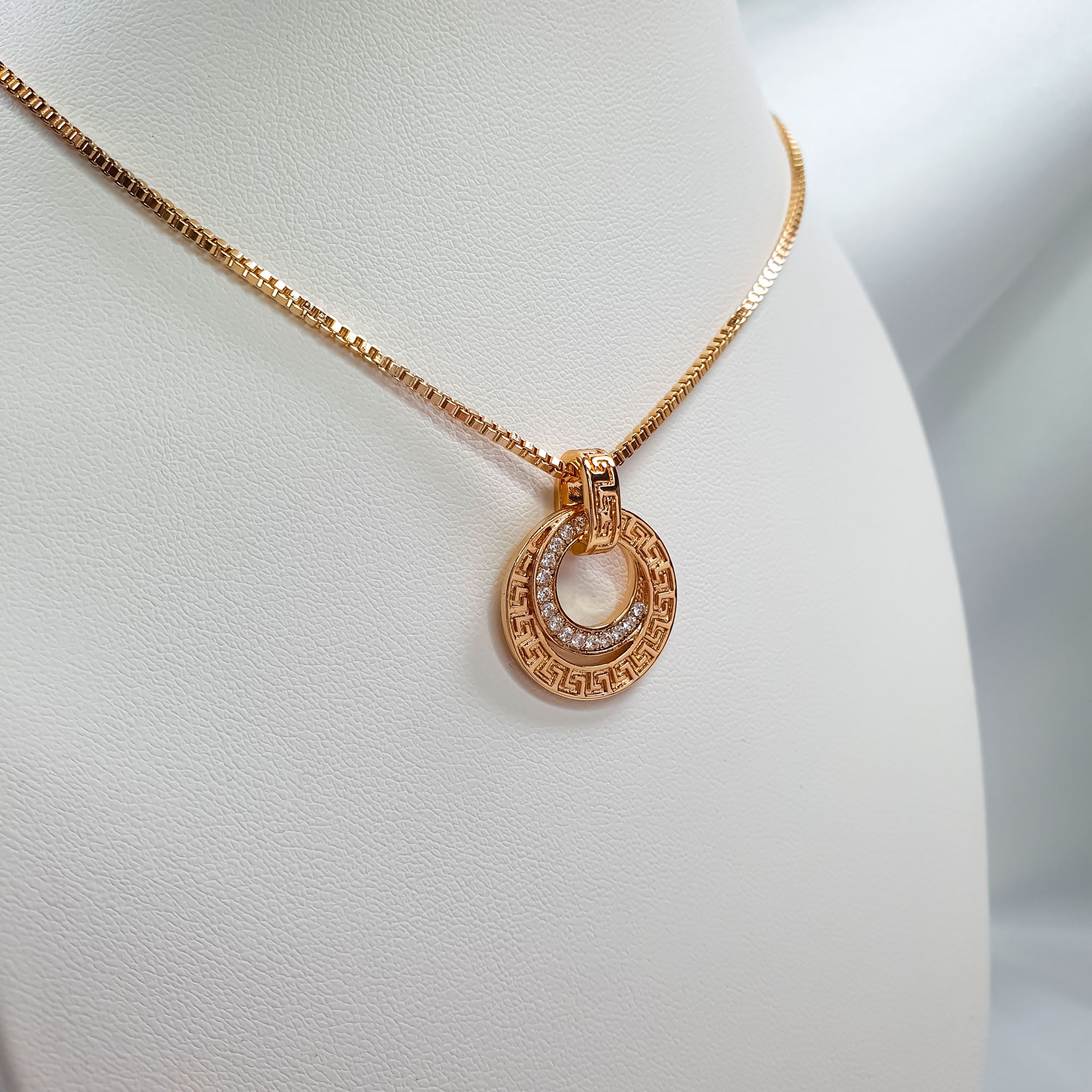 Sieviešu piekariņš divu apļu formā ar antīku rakstu un baltiem kristāliem