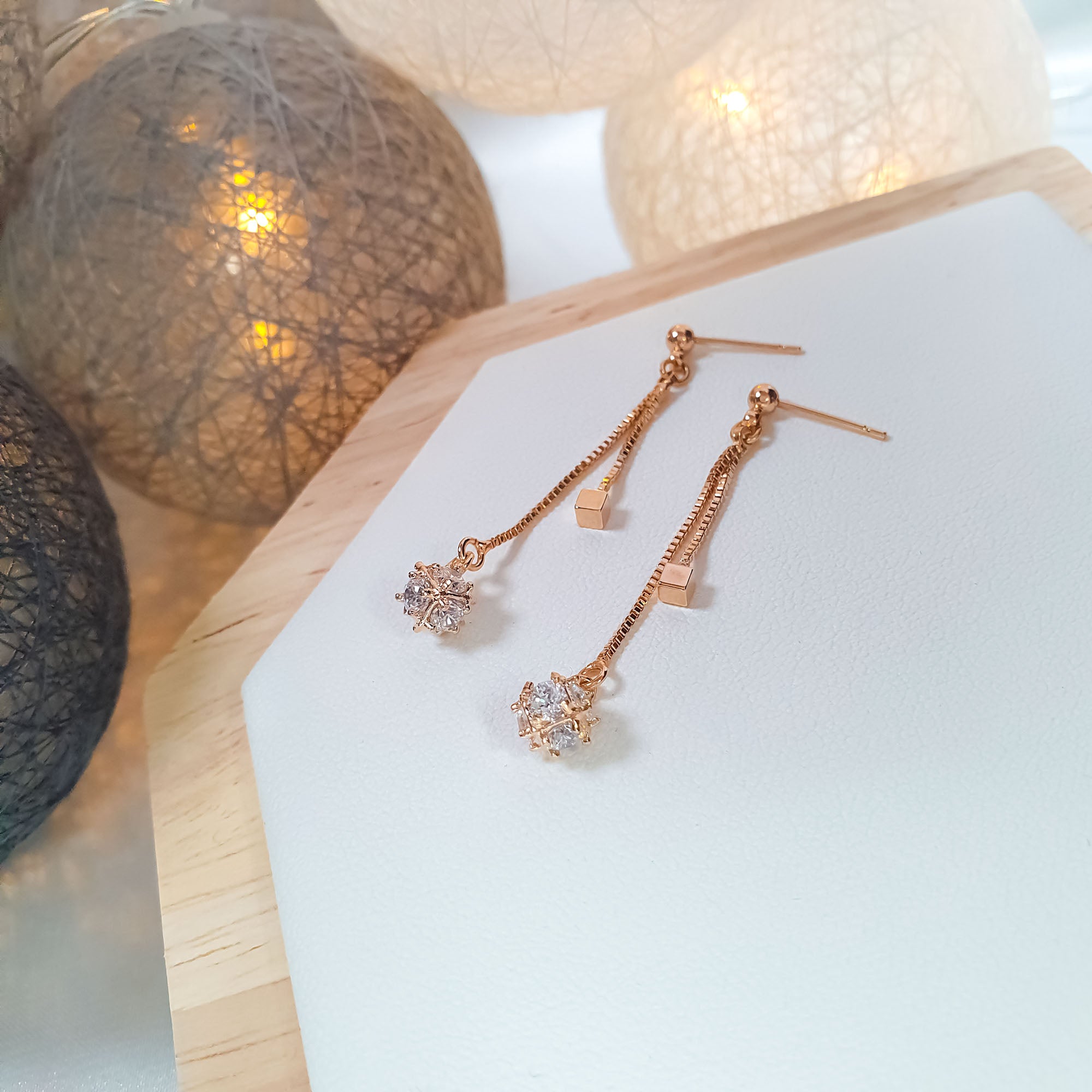 Sieviešu auskari ar plūstošu ķēdi un dzirkstošu akmeņu centru