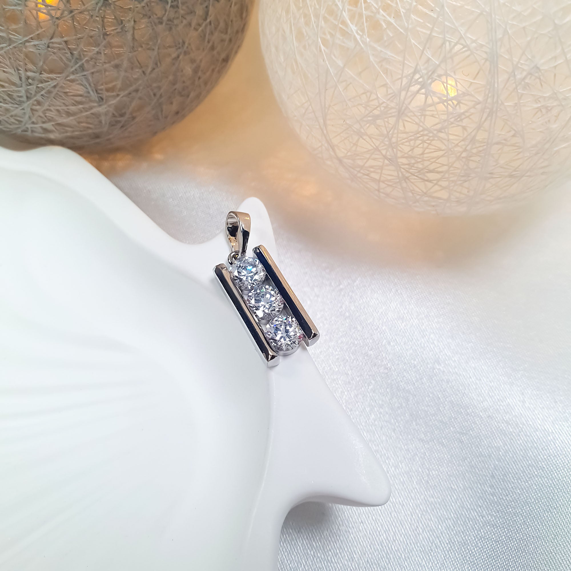 Sudraba toņa kulons ar lineāru cirkonu kompozīciju