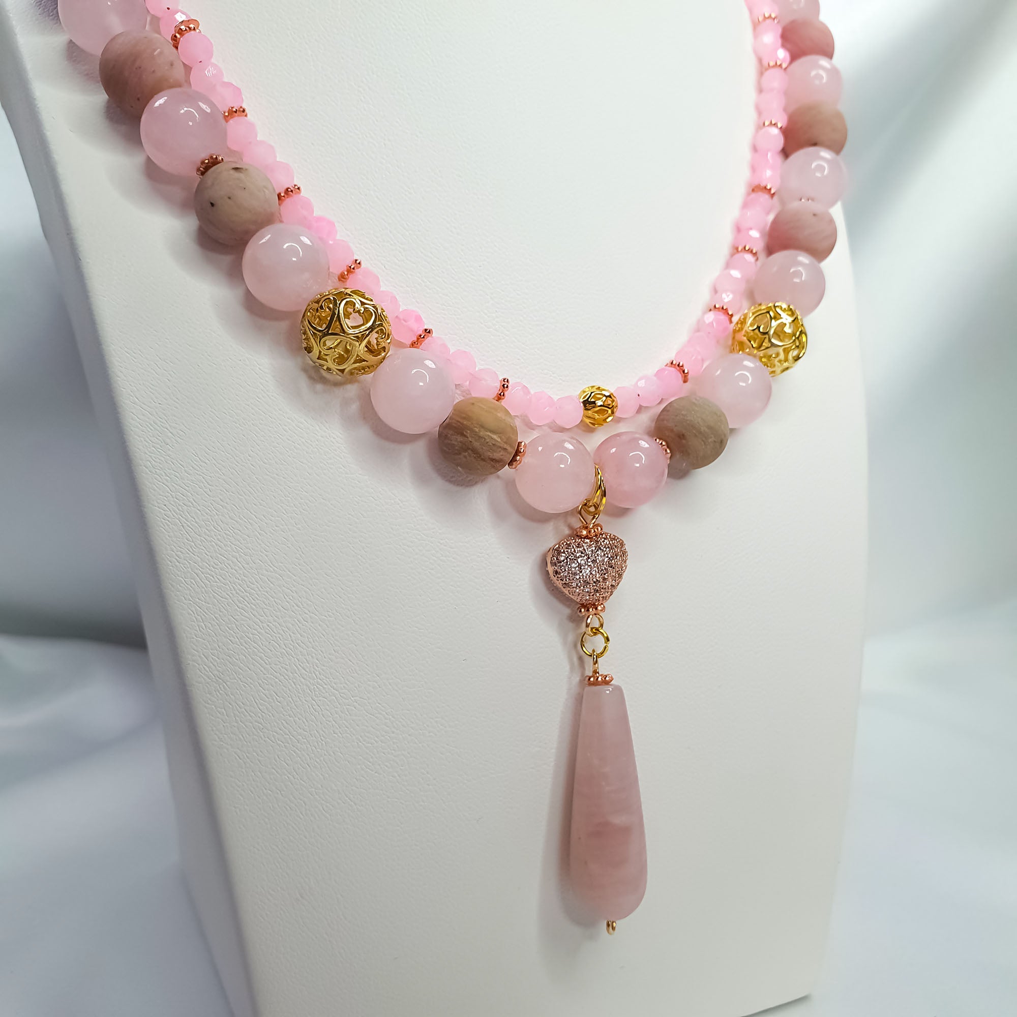 Rozā akmeņu krelles ar divām virtenēm un kvarca lāses formas piekariņu