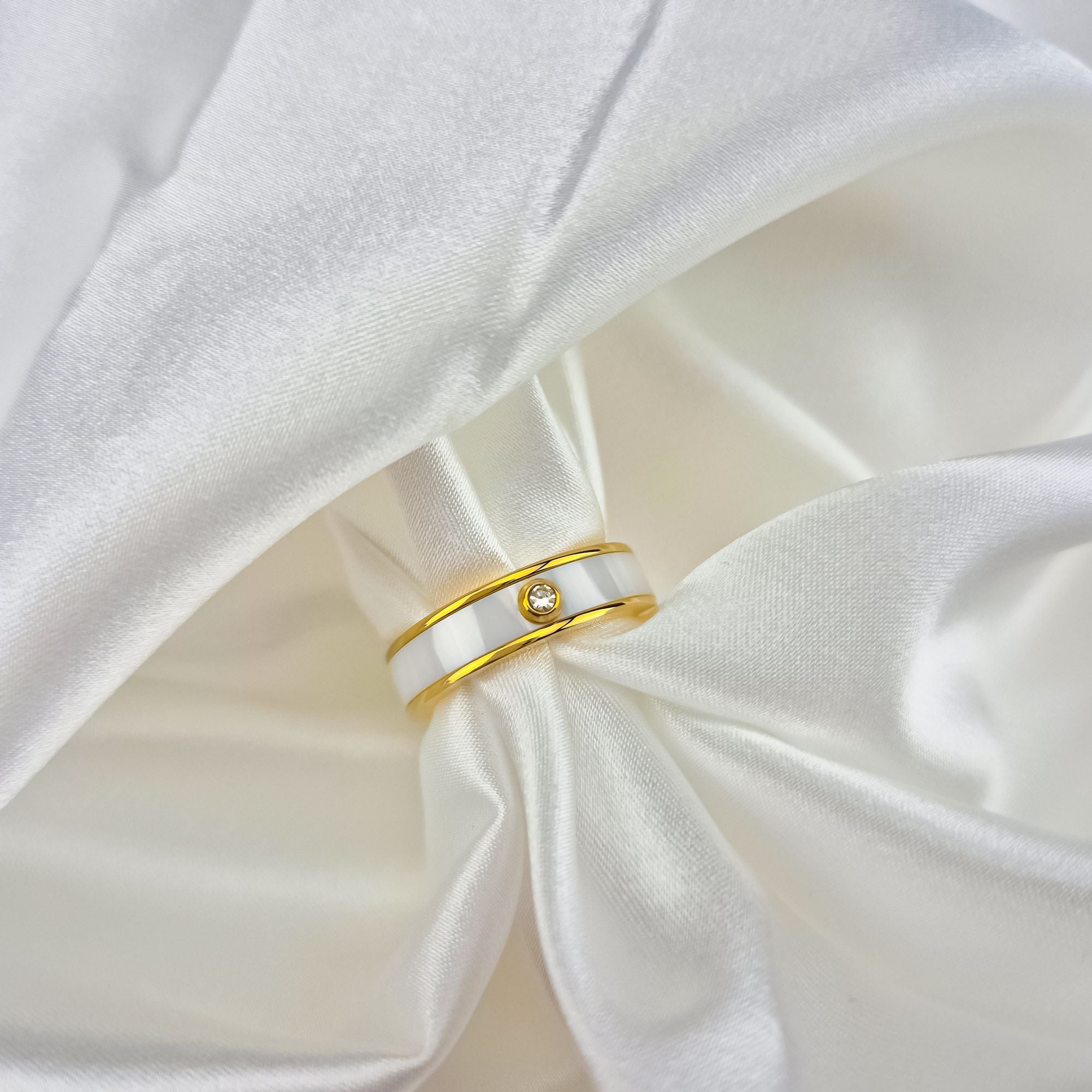 Elegants gredzens zelta tonī ar balto keramiku, stilīgai un izsmalcinātai nēsātājai